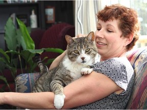 Ev Neighbour of High River was reunited with her cat Satan, 13, on Monday. He went missing during the floods last June only to show up on his old window sill almost a year later. (Lorraine Hjalte/Calgary Herald)
