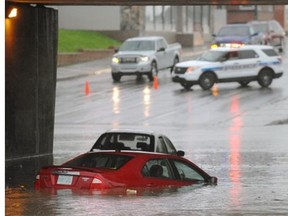 A partially submerged car at Sask. Dr. and Albert St. during an afternoon downpour in Regina, Sask. on Sunday June 29, 2014. (Michael Bell/Regina Leader-Post)