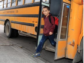 Kids arrive by bus on the first day of school at St Thomas Aquinas  Elementary School in Glamorgan.