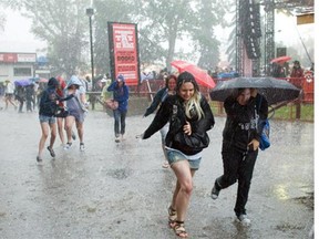 FILE PHOTO - JULY 12, 2010:  Stampede goers run for cover during a severe rain and hail storm.