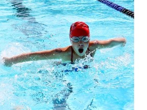 Sara Rousselle, 9, participates in the Kids’ Swim-A-Thon as she swims laps at the Silver Springs Outdoor Pool to help save the dive tank, in Calgary on July 20, 2014.