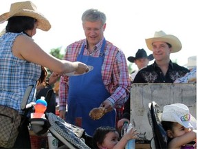 Prime Minister Stephen Harper serves up pancakes at the Chinook Centre pancake breakfast on July 5, 2014.