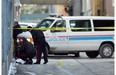 Calgary police investigators at the scene where the body of murder victim Mark Kim, was found in an alley west of 8th St. SW between 6 and 7 Ave in December, 2007.