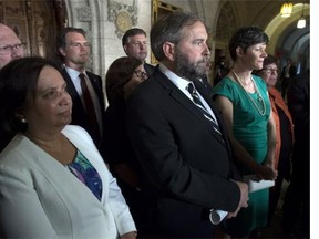 NDP leader Tom Mulcair stands with his environment critic megan leslie(right) and B.C. members of the NDP as he responds to the governments decision to approve the Northern Gateway pipeline Wednesday June 18, 2014 in Ottawa.