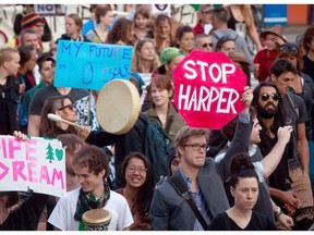 In this  file photo, a protester holds up a "Stop Harper" sign while marching with others during a rally held to show opposition to the Enbridge Northern Gateway pipeline. Reader fears such fallout will jeopardize Canada's reputation.