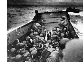 In this file photo, allied troops crouch behind the bulwarks of a landing craft as it nears Omaha Beach during a landing in Normandy, France.