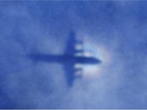In this March 31, 2014 file photo, a shadow of a Royal New Zealand Air Force P-3 Orion aircraft is seen on low cloud cover while it searches for missing Malaysia Airlines Flight 370 in the southern Indian Ocean.