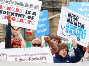 People protest cuts to refugee health services on Parliament Hill last June. The federal government should live up to its obligations and reinstate medical coverage for all refugees, says the Herald editorial board.