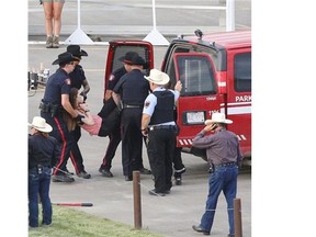 Police carry out one of the two protesters who was chained to the infield fence during Day 1 of the Rangeland Derby at Stampede Park.