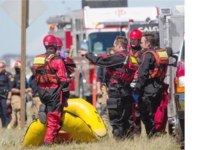 Police and emergency crews on the scene after a body was found in a pond near Stoney Trail and 16th Avenue in Abbydale on Thursday.