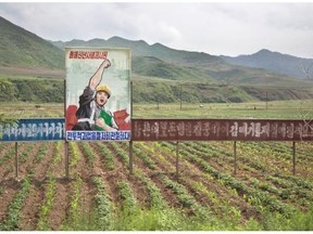 A propaganda billboard stands in a field south of Samsu, in North Korea’s Ryanggang province. The sign reads: “Let’s complete the tasks set forth in the New Year’s address.”
