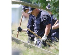 RCMP scour a property northeast of Airdrie Saturday afternoon. Authorities are remaining tight lipped about the nature of the investigation. Photo by David Moll/For the Calgary Herald