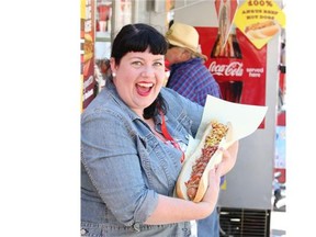 Reporter Gwendolyn Richards tries her hand at the two-foot long hotdog at the Calgary Stampede.