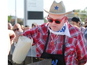 Rick Kruesel pours batter to start some pancakes cooking at the Chinook Centre pancake breakfast on July 5, 2014.
