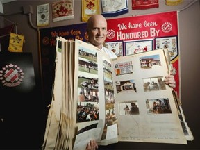 Rick Kuzyk peruses some of the scrapbooks from 50 years of the Kinsmen Club of Stampede City on Friday after the club announced a donation of $1.31 million to 11 different Calgary charities.