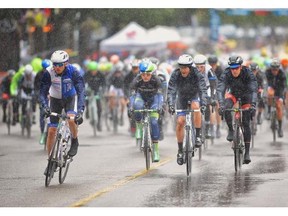 Riders finish a lap of the ATB Financial Tour of Alberta Stage 1 circuit, in the pouring rain and cool temperatures, in Lethbridge on Wednesday. German Ruben Zepuntke thrived in the environment, rolling to victory.