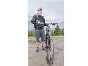Robert Earl braves the rain at Parks Canada’s announcement of a new network of bike trails in Banff. (Crystal Schick/Calgary Herald)