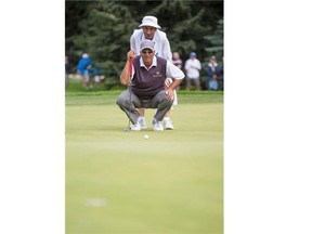 Rocco Mediate gets a little help from his caddy to line up a putt during the first round of the Shaw Charity Classic on Friday afternoon.