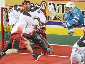 Rochester Knighthawks’ Cory Vitarelli, right, goes airborne as he takes a shot on Calgary Roughnecks goalie Mike poulin during Game 1 of the National Lacrosse League’s Champions Cup final at the Scotiabank Saddledome last Saturday.