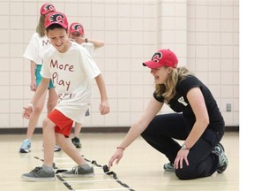 Rosedale School Grade 5 student Gianluca Cortese works with the Eau Claire YMCA’s youth and preschool director Jenni Thompson on Thursday after the announcement of the Flames Foundation partnership for a program with the YMCA to provide all Grade 6 students in Calgary with a free membership beginning Sept. 1.