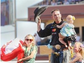 Scott Schiffner of Strathmore celebrates with his family after taking home the bronze trophy in the bull riding event at the Calgary Stampede on Sunday.