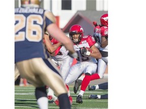 Sederrik Cunningham of the Calgary Stampeders carries the ball up field against the Winnipeg Blue Bombers during the first half at McMahon Stadium in Calgary on Saturday June 14, 2014. (Jenn Pierce/Calgary Herald)