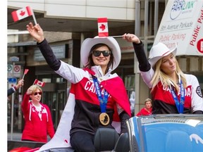 Slopestyle skiers Kim Lamarre, left, with her bronze medal, and gold-medallist Dara Howell wave Canadian flags during the Parade of Champions on Friday.