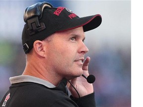 WINNIPEG, MB - JULY 3: Rick Campbell, head coach of the Ottawa RedBlacks looks to the replay in first half action in a CFL game against the Winnipeg Blue Bombers at Investors Group Field on July 3, 2014 in Winnipeg, Manitoba, Canada.