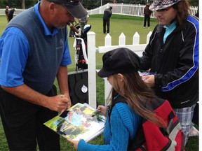 Rocco Mediate signs a photo for 10-year-old Brin Santoro and her father.