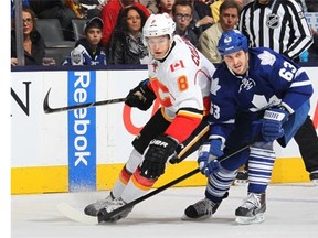 Joe Colborne of the Calgary Flames skates against David Bolland of the Toronto Maple Leafs during an NHL game at the Air Canada Centre on April 1, 2014 in Toronto.