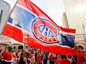 Montreal Canadiens fan Jean-Francois Gordon-Masmarti carries a Canadiens flag outside the Bell Centre prior to Game 6 of Stanley Cup playoff series against the Boston Bruins in Montreal Monday May 12, 2014.