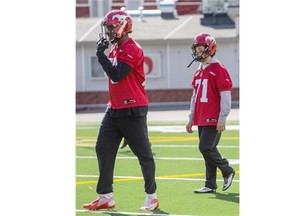 Stampeders kicker Tyler Crapigna, right, walks behind teammate Aldarius Johnson, left, at McMahon Stadium. Crapigna is the smallest player in Stamps camp, but he doesn’t let hold him back.