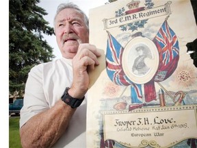 Doug Lacey, holding a poster with a photograph of his grandfather, in Taber, Alberta Wednesday, July 16, 2014.