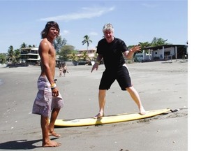 Surf instructor Fred Martines works on the unenviable task of instructing Ted Rhodes on the fine art of surfing in the Nicaraguan beach village of Las Pinitas.