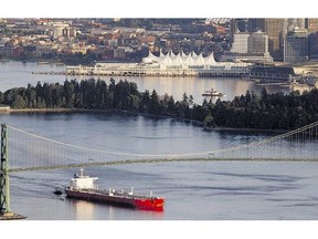 An oil tanker guided by tugs sails under the Lions Gate Bridge in Vancouver, B.C. in May 2012.