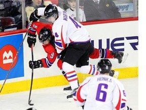 Team Orr defenceman Brycen Martin, right, from the Swift Current Broncos, drives Team Cherry forward Chase De Leo, left, from the Portland Winterhawks, into the boards during the CHL/NHL Top Prospects game at the Scotiabank Saddledome last January.