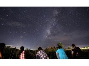 This long-exposure photograph taken on August 12, 2013 shows people watching for the Perseid meteor shower in the night sky near Yangon.