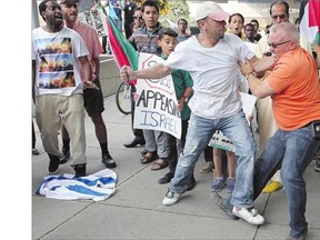 Tempers flare between pro-Palestinian and pro-Israeli factions during a protest over Israel's invasion of Gaza outside City Hall on Friday.