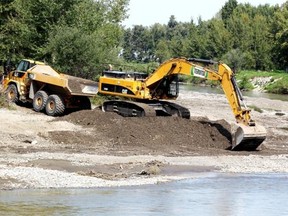 Tervita’s heavy equipment works along the banks of the Highwood River in High River on August 2013. (Colleen De Neve/Calgary Herald)