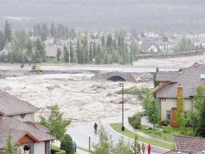 THEN: A major roadway disappears into the raging water as Canmore homes along Cougar Creek barely hang on during massive flooding Thursday, June 20.