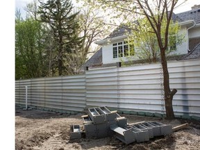 Thick aluminum panels made watertight by commercial-grade silicone sealant encircle an Elbow Park home to protect it from flood waters. The panels are removable so they can be put up and taken down as needed.