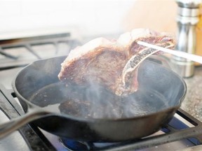 In this May 5, 2014 photo, a steak is pan seared in Concord, N.H. Certain small steps - heating the pan properly, patting the meat dry before putting it in the pan - help ensure success. (AP Photo/Matthew Mead)