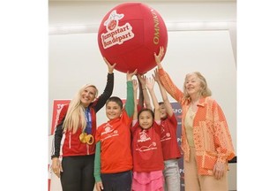 Two-time Canadian Olympic gold medalist Kaillie Humphries, left, poses with some students from Patrick Airlie School and Martha Billes, Canadian Tire Jumpstart Charities, right, as part of the Jumpstart Day and Red Ball campaign in Calgary on Thursday.