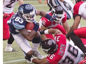 Toronto Argonauts’ Terrell Sinkfield is tackled by Calgary Stampeders’ Glenn Love during Saturday’s game. Love had come on for injured starting linebacker Deron Mayo.