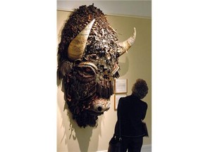 FILE - This Jan. 27, 2006 file photo shows a woman looking at Buffalo, a mixed media piece by artist Holly Hughes, part of the Capitol Art Collection at the Capitol in Santa Fe, N.M. The collection was created in 1991 and consists of nearly 600 works exhibited in the building’s public spaces and on the grounds outside. The collection is currently valued at more than $5.6 million. (AP Photo/Jeff Geissler, File)