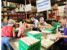 Volunteers Don Watson, from left, Marie Mullin, Carolyn Renouf, Art Dobson, Gilbert Cordell and Margaret Bon work on the delicate task of repackaging eggs into cardboard containers at the Calgary Inter-Faith Food Bank.