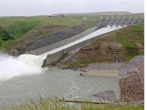 Water pours through the Oldman River Dam on Tuesday. The reservoir was being lowered in anticipation of heavy rain and possible flooding.