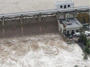 Water thunders over the top of the Glenmore dam at the Glenmore reservoir on Friday. Calgary’s water treatment facilities are operating at capacity, prompting mandatory restrictions on water usage.