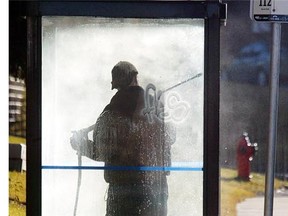 A worker removes graffiti from a Calgary bus stop. (Calgary Herald/Files)