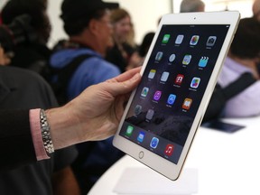 An attendee inspects new iPad Air 2 during an Apple special event on October 16, 2014 in Cupertino, California.